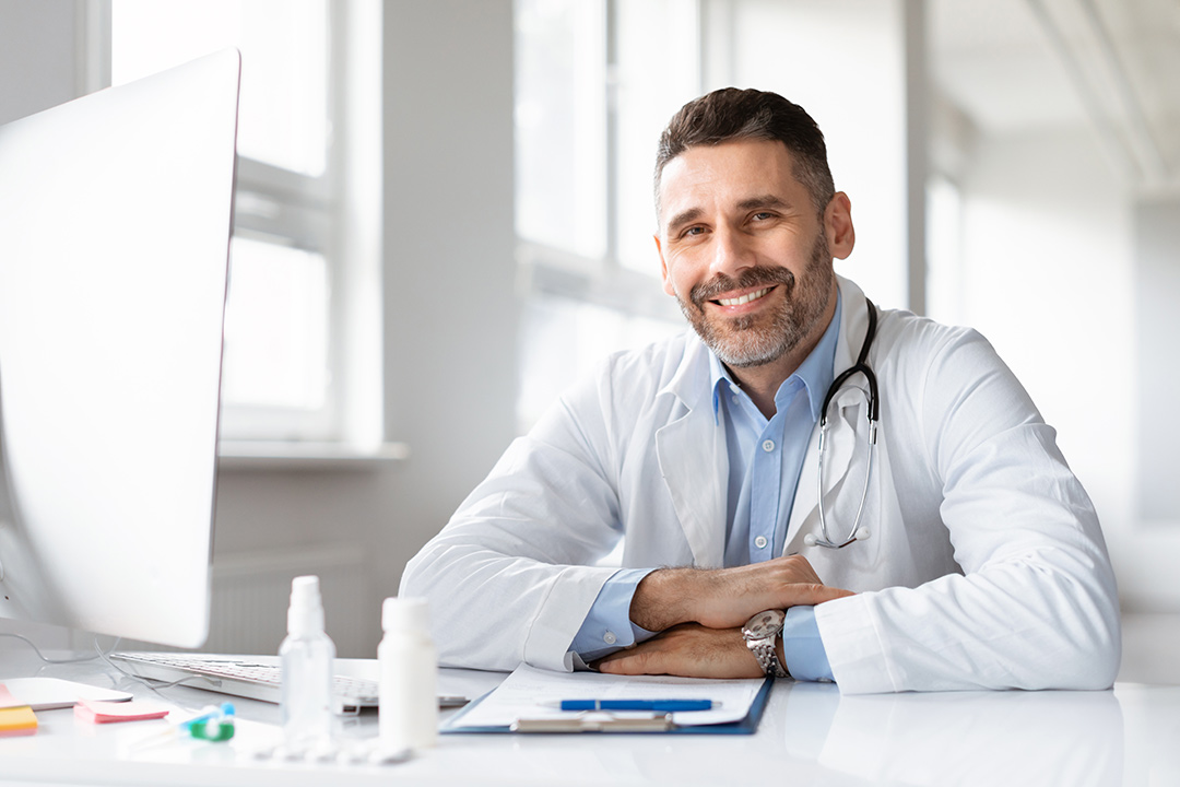 Happy male doctor in white medical uniform specializing in weight management and pain management at OHR Medical.